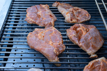 A grill with meat on it. The meat is brown and has a lot of seasoning on it