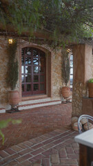 An empty mediterranean doorway framed by lush foliage and stone walls at dusk, exuding a tranquil, inviting atmosphere.