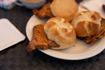 Three sandwiches are on a white plate, with one of them being a chicken sandwich