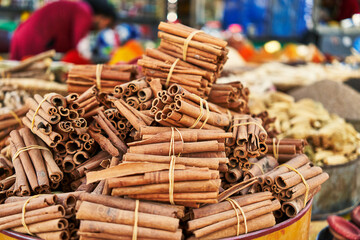 A colorful display of bundled cinnamon sticks at a vibrant street market.