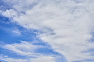 A serene blue sky scattered with wispy white clouds reflecting tranquility and vastness.