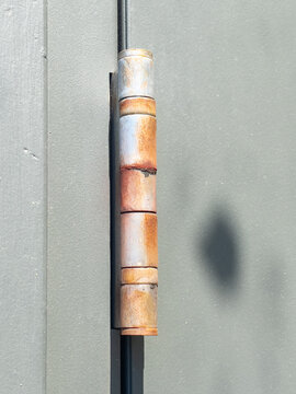 A rusty door hinge on a commercial door.
