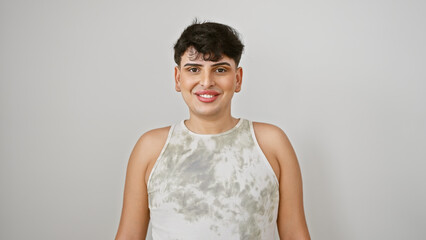 Confident young adult male smiling in a casual white tank top against a plain background.