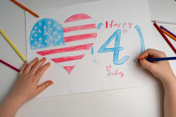 The American flag is drawn with pencils by children's hands. Children's hands draw a flag....