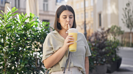 Young beautiful hispanic woman drinking bubble tea in the streets of Vienna