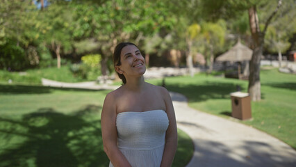 A smiling young hispanic woman enjoys the serene outdoor setting of a luxurious bali resort.