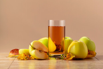 Apple juice and ripe apples with dried-up leaves.