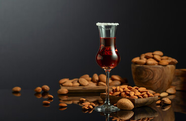 Italian liqueur Amaretto with almonds nuts on a black background.