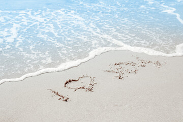 beautiful drawings inscription on the sand of the sea in the summer on the nature