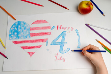 The American flag in the form of a heart with the inscription July 4 is drawn with pencils by the hand of a child. Patriotism, Independence Day, Flag Day Concept. Memorial Day