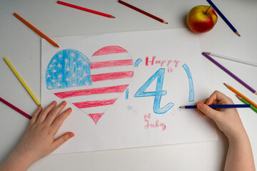The American flag in the form of a heart with the inscription July 4 is drawn with pencils by the hand of a child. Patriotism, Independence Day, Flag Day Concept. Memorial Day