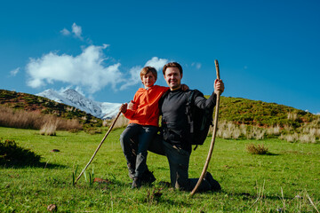 Portrait of man hiker with his son in the mountains in spring