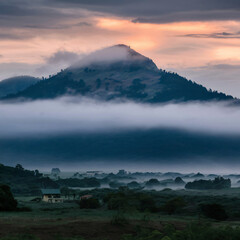 A landscape photograph of a mountain veiled in morning fog, capturing a moment of ethereal beauty.