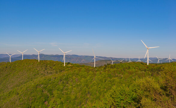 fields of wind turbines on the French hills in the herault on a blue sky background.