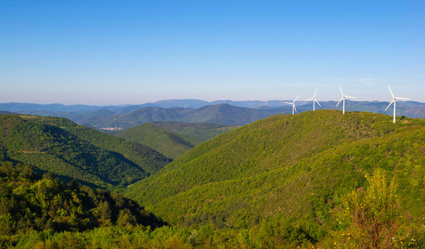 fields of wind turbines on the French hills in the herault on a blue sky background.