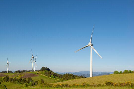 fields of wind turbines on the French hills in the herault on a blue sky background.