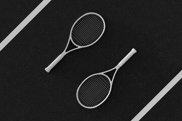 White tennis rackets on black hard tennis court. White line in corners.
