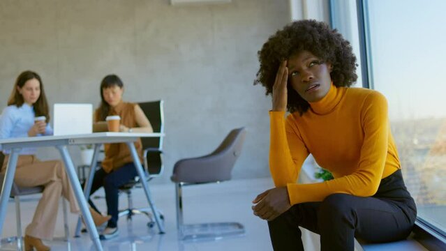 Discriminating co-workers. 4k video footage of a young businesswoman looking stressed out during a team meeting in a modern office. Worried young businesswoman