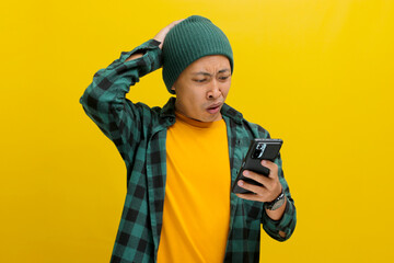 An unhappy Asian man, dressed in a beanie hat and casual shirt, reacts to a message with bad news...