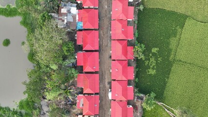 Drone aerial view of a village with clustered houses surrounded by green fields in rural Bangladesh