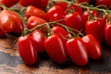 Delicious mini San Marzano tomatoes in wooden background. Organic