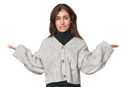 Middle Eastern woman in studio confused and doubtful shrugging shoulders to hold a copy space.