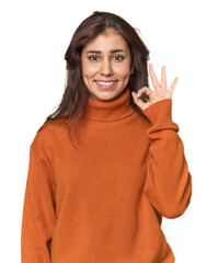 Middle Eastern woman in studio cheerful and confident showing ok gesture.