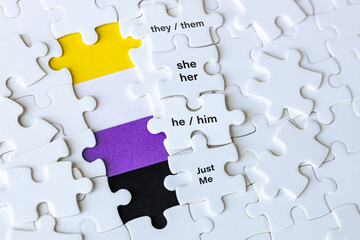 A removed puzzle showing the symbol of non-binary people and the words they them, she her, he him, just me. Concept, gender diversity, people with non-binary gender identity, transgender people.