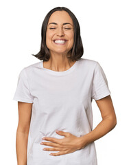 Fototapeta premium Young Caucasian woman with short hair touches tummy, smiles gently, eating and satisfaction concept.