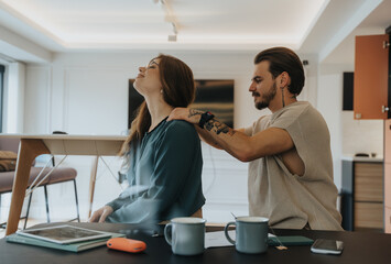 A caring man treats his partner to a calming massage, creating a moment of tranquility at work.