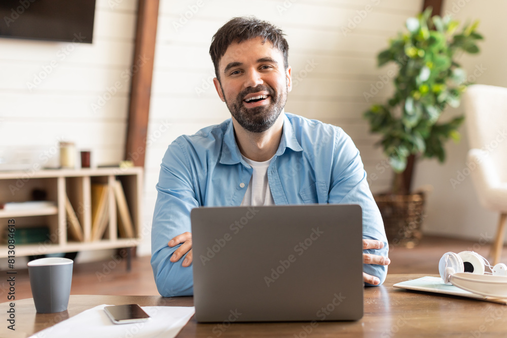 Poster A man is seated in front of a laptop computer, typing on the keyboard and staring at the screen. He appears focused and engrossed in his work.