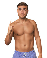 Fototapeta premium Young man shirtless in swimwear, studio having some great idea, concept of creativity.