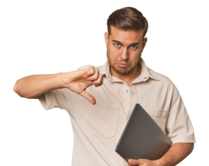 Man holding laptop, studio showing a dislike gesture, thumbs down. Disagreement concept.
