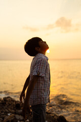 Young Boy Enjoying a Beautiful Sunset By the Sea