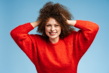 Smiling woman, plus size model with curly hair wearing stylish red sweater with nice hairstyle