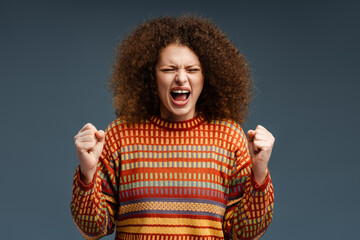 Upset, unhappy woman with curly hair with closed eyes screaming standing isolated on gray background - Powered by Adobe