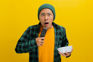 Startled young Asian man, adorned in a beanie hat and casual shirt, wearing a shocked expression,...