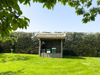 Beehives in an open shed on green garden grass in spring. Active beekeeping scene with buzzing bees.