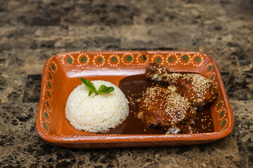 White rice with chicken pieces bathed in red mole sauce, Mexican food