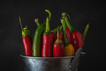 Red Chili Peppers in a bucket on old wooden background. Food background.