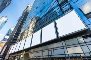 Obraz premium Modern building flaunts empty billboards on its sleek facade, city street below.