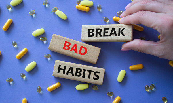 Break bad habits symbol. Concept words Break bad habits on wooden blocks. Beautiful purple background with pills. Doctor hand. Medicine and Break bad habits concept. Copy space.