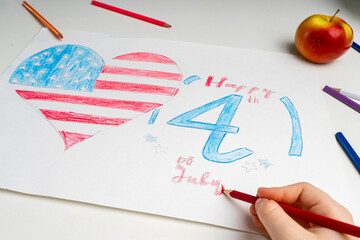 The American flag in the form of a heart is drawn by the child's hand with a red pencil. The Fourth...