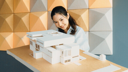 Skilled attractive architect engineer holds architect model while checking mistake point carefully....