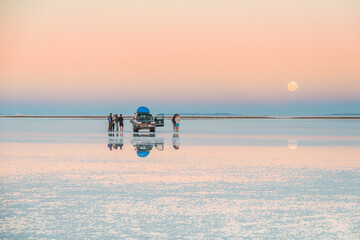 Reflections at Salar de Uyuni during sunset (April) - 4x4 Jeep and tourists behind mountain and mirror lake