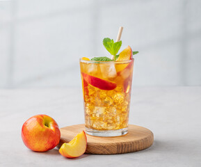 Refreshing peach iced mint tea. The concept of a healthy homemade cold summer drink in a tall glass