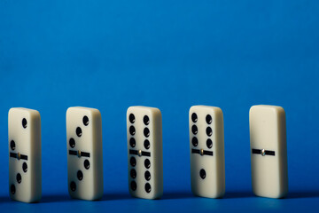 Dominoes standing on a blue background.