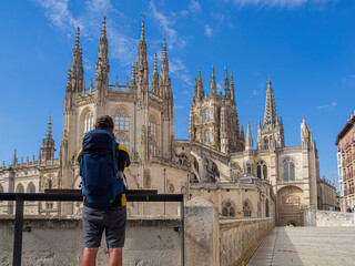 Turista con mochila azul, admirando la Catedral de Burgos de estilo gótico, en España, viajando...