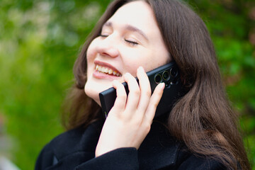 Smiling woman talking on cell phone in the street