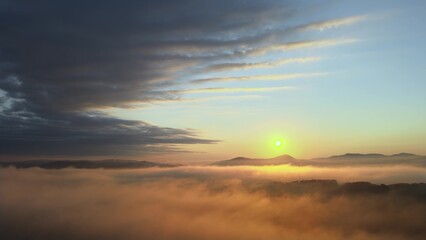 Aerial View of Majestic Colorful Sunrise Sunlight Above Landscape with clouds and fog. Drone Shot